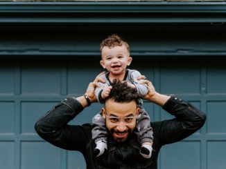 un homme porte son enfant sur les épaule comme preuve de paternité
